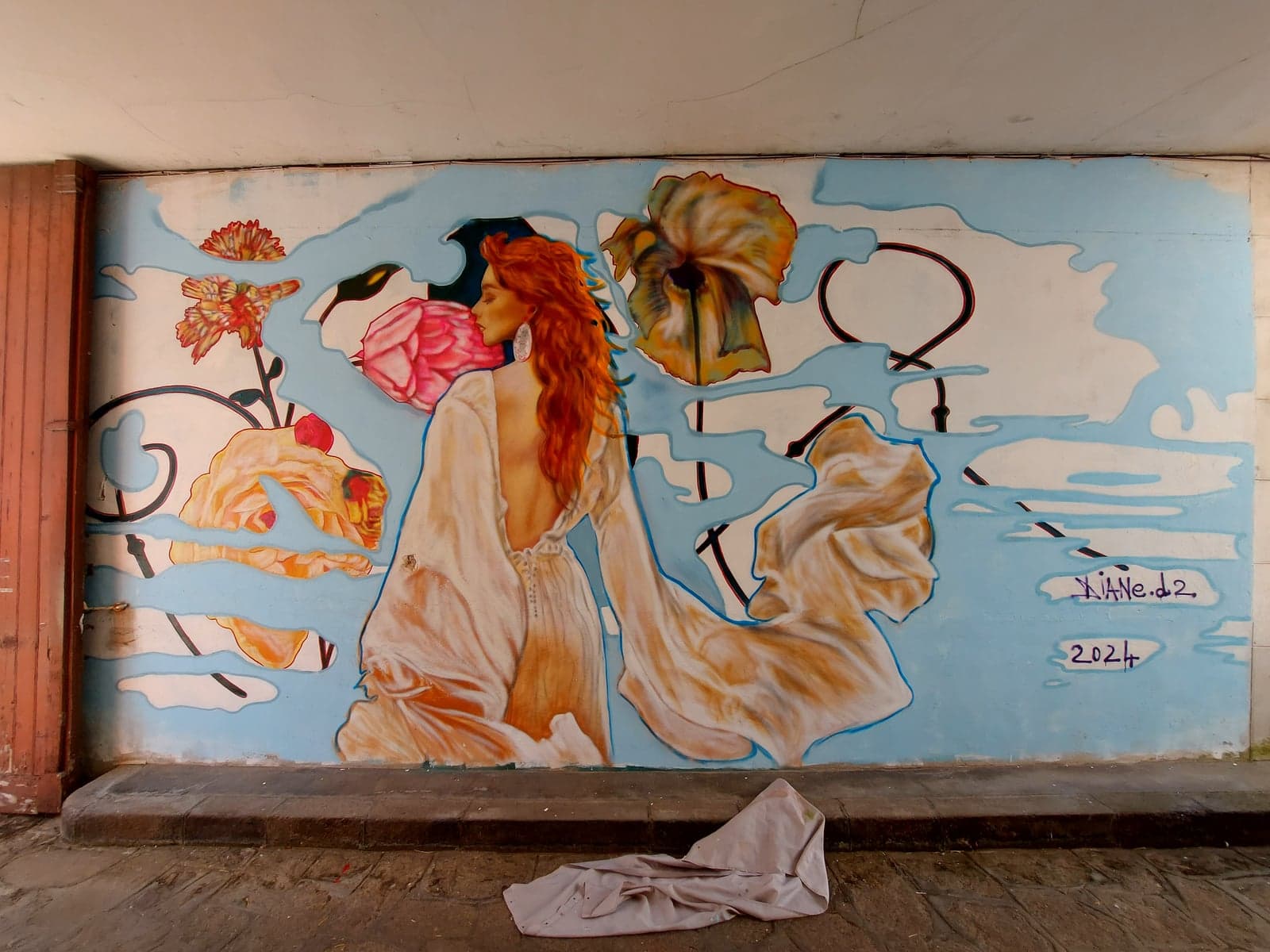 Fresque sous porche — femme rousse de dos, fleurs et pivoine rose